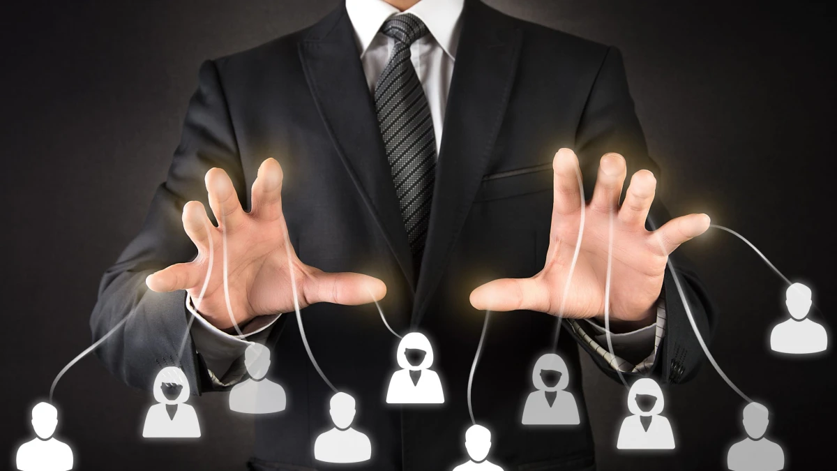 A photomontage of hands in front of a suit linked by lines to people icons