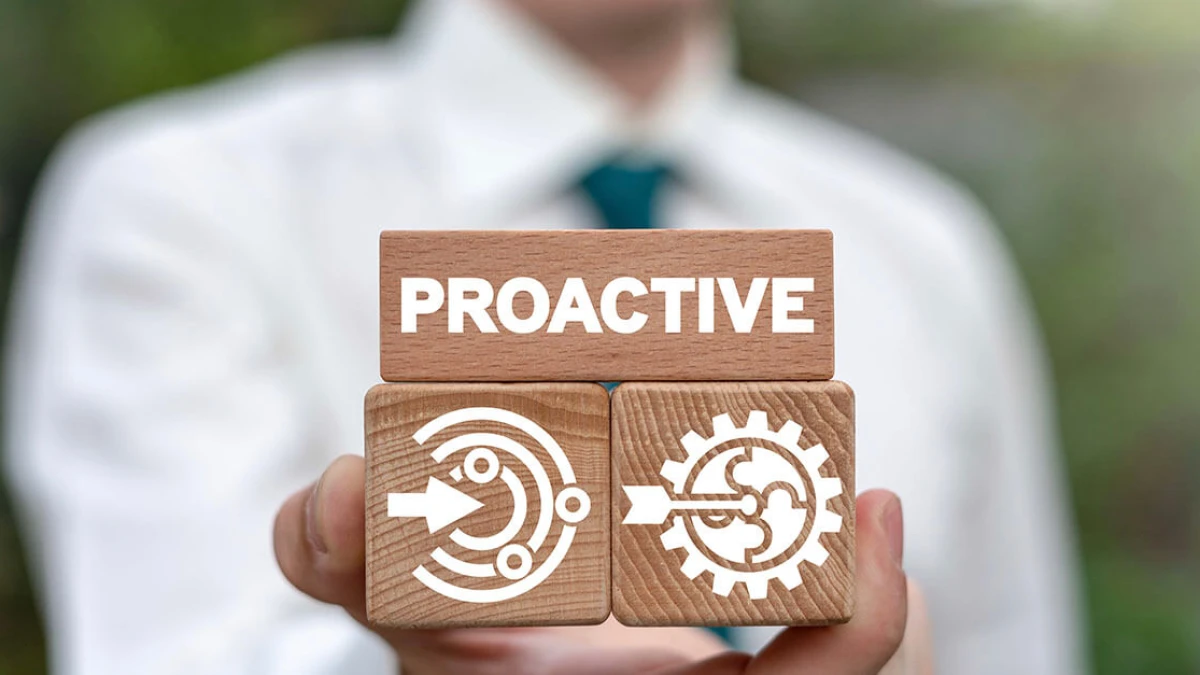 A hand holding wooden blocks with Proactive text, a target and a gear